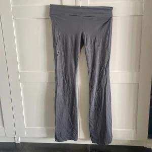 Grå bootcut mjukisbyxor - Snygga grå mjukisbyxor med bootcut-ben och bred resår i midjan. Byxorna är i ett mjukt och stretchigt material som känns skönt mot huden. Perfekta för en chill och avslappnad stil.