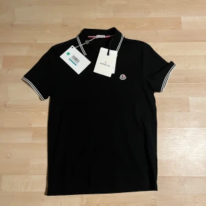 Svart Moncler pikétröja med logga - Sjukt fet Monclerpiketröja med lappar kvar, samt äkthetsverifiering. Priset kan diskuteras 