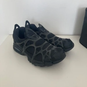 Nike Air Kukini Storlek 43 - Futuristisk Nike Air modell som ej längre säljs i Sverige. Inköpspris var 900kr, endast använt skorna vid ett par tillfällen. perfekt addering om ni vill maxxa eran dark goth y2k outfit 💯🔥