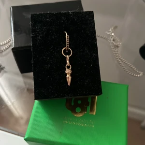 Guldörhänge med spetsig charm - Snyggt örhänge i guld med en liten spetsig charm som hänger ner. Ringen har små detaljer och ger ett coolt och trendigt intryck. Perfekt accessoar för att lyfta din stil.