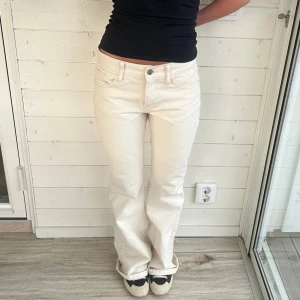 Vita jeans  - Lågmidjade cremevita jeans med bootcut. Storlek S, Midja: 38x2 cm innerben: 80 cm