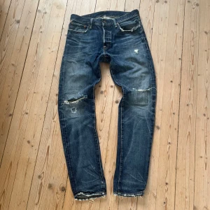 Ralph Lauren jeans med hål och revor - Säljer ett par vintage jeans från Ralph Lauren med snygga slitningar och trasiga detaljer vid knän och fickor. Jeansen har en tajt passform, storlek 31/32 men de är mindre i storleken. Nypris är oklart, mitt pris 150kr.