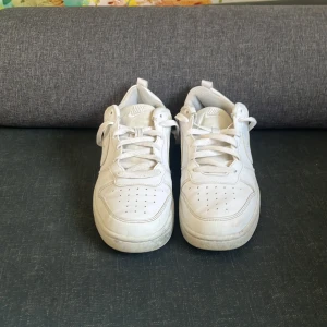 Vita Nike sneakers. Kan gå ner i pris och kan skicka mer bilder(: Sulan är lite sönder men det syns inte. - Klassiska helvita Nike sneakers i skinn med rund tå och snörning. Snygg och clean look med diskret Nike-logga på sidan och perforerade detaljer på tån för extra ventilation. Perfekta för dig som gillar stilrena och tidlösa sneakers.