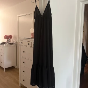 Svart långklänning - Säljer denna svart långklänning med tunna axelband från pull and bear, använd fåtal gånger.