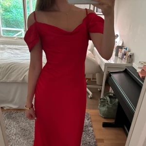 Röd långklänning med offshoulder - Jättefin röd långklänning i satin med draperad urringning, off shoulder och justerbara axelband. Endast använd en gång!