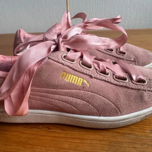 Puma Sneakers, Rosa, Storlek 37 - Ett par rosa sneakers från Puma med satinband som skosnören. Innersulan har ett blommigt mönster.