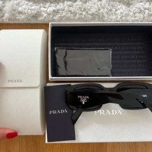 Svarta solglasögon Prada - Snygga svarta solglasögon från Prada med rektangulära bågar och klassisk logga på sidorna. Kommer med vitt fodral och originalförpackning. Använd fåtal gånger inga defekter! Nypris 2 500 ÄKTAHETSBEVIS FINNS 🙌🏼