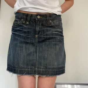 Mörk jeanskjol💙 - Trendig mörkblå jeanskjol med fickor fram och bak, samt en lite fransig kant med till. Kjolen stängs med knapp och dragkedja. Den är i mycket fint skick och är knappt använd!!💙Från midja till nederkant-37cm. Men kanten skulle lätt kunna sys upp. Kjolen är i strl 38💞💞💞