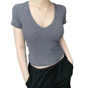 Randig croppad topp med v-ringning - Randig croppad topp med v-ringning och korta ärmar. Toppen är ribbad och har en slim passform som sitter snyggt på kroppen. Perfekt för sommaren, jätteskönt tunt material!!