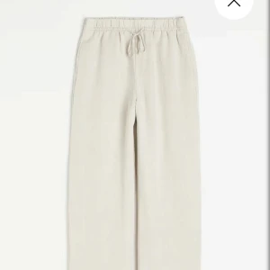 Beiga linnebyxor med resårmidja - Säljer ett par beiga linnebyxor med avslappnad passform och resår i midjan. Perfekta för varma dagar och ger en chill vibe. Lätta och luftiga, passar till sneakers eller sandaler. Nya med prislapp på. 