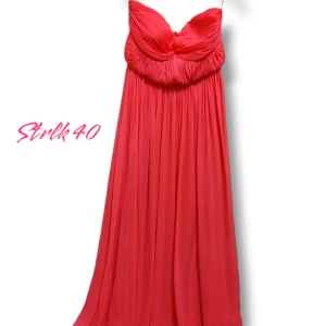 Röd/Rosa bal/ Fest långklänning från Gina Tricot - Maxiklänning i röd/rosa färg från Gina Tricot. Färgen syns inte tydligt på bilderna pga belysningen. Klänningen har smala axelband, plisserad överdel med elegant fall. Perfekt för dig som vill stickaka ut. Har inte kommit till användning 