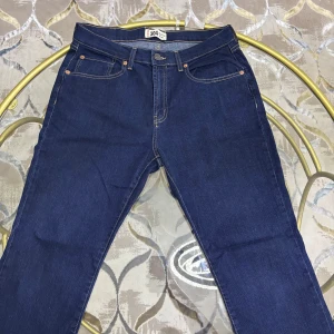 Mörkblå jeansbyxor straight fit - Mörkblå jeansbyxor från 304 med klassisk femficksdesign och raka ben. Byxorna har kontrastsömmar och knappgylf. Perfekta för dig som gillar en enkel och tidlös look.