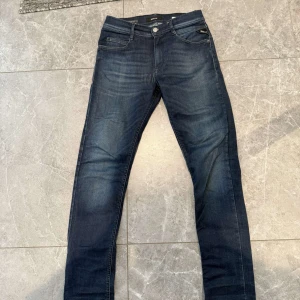 Replay mörkblå jeans slim fit - Snygga mörkblå jeans från Replay med klassisk femficksdesign och diskreta slitningar. Jeansen har smal passform och raka ben, tillverkade i stretchig denim för extra komfort. Perfekta för dig som gillar en stilren och modern look. Dm för frågor🙌⭐️