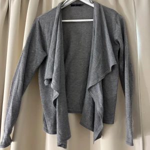 Kofta  - Superfin, stilren grå kofta med omlott-design. Tunn och väldigt skönt material. Om fler bilder önskas eller vid frågor kontakta mig💋