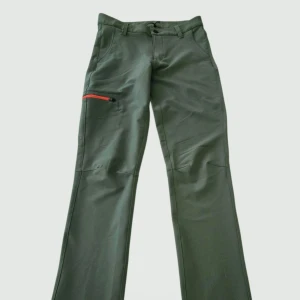 Grå softshellbyxor från Mckinley - Snygga softshellbyxor från McKinley med röd dragkedja på benfickan och röd bältesögla baktill. Dessa softshellbyxor är optimerade för utomhusaktiviteter och tillverkade i ett slitstarkt, andningsbart material. Den höga midjan ger en bra passform, och fyrvägsstretchen säkerställer maximal rörelsefrihet. Två öppna sidfickor, en bakficka samt en benficka med dragkedja håller dina nödvändigheter säkra när du är 