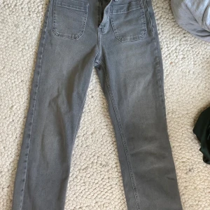 Grå jeans med raka ben - Snygga croppade grå jeans med fickor både fram och bak. Materialet är mjukt och följsamt jeans. Storlek S från Zara