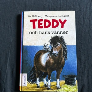 Teddy och hans vänner - En charmig bok om Elsa som får börja rida Teddy på riktigt! Perfekt för unga djurälskare, med korta kapitel, stor stil och många bilder. Följ med på äventyr bland hästar, katter och andra djur på gården. Passar dig som gillar lättlästa och roliga berättelser.