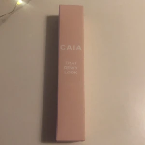 CAIA That Dewy Look highlighter - Säljer en CAIA That Dewy Look eye gloss i snygg rosa förpackning. Perfekt för att få den där fräscha glowiga finishen.