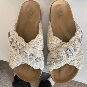 Beige sandaler med silvriga stenar - Snygga sandaler i beige stickad bomull med grova korsade band och silvriga stenar som detaljer. Använda fåtal gånger så är o bra skick, 1 Sten har kommit bort (se bild 2)💗☀️Ny pris 550kr