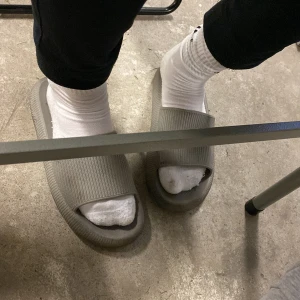 Grå chunky sandaler i syntet - Chunky grå sandaler med bred rem över foten och platt sula. Tillverkade i syntetmaterial och har en modern, minimalistisk look. Perfekta för en avslappnad stil och funkar lika bra med strumpor som utan.