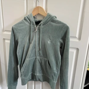 Juicy Courture - Velour Robertson Zip Hoodie Chinois Green - Grön zip hoodie från Juicy Couture i storlek xs. Den är i mycket bra skick och har inga defekter. Säljes då jag vuxit ur den💞