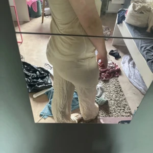 Beiga vida linnebyxor med snörning - Säljer ett par superbekväma, vida linnebyxor i beige med resår och snörning i midjan, högmidjade men går att vika ner så dom blir Lågmidjade.Byxorna har en avslappnad passform och är tillverkade i ett luftigt linnematerial, perfekta för varmare dagar. Stilrena och lätta att matcha med allt.