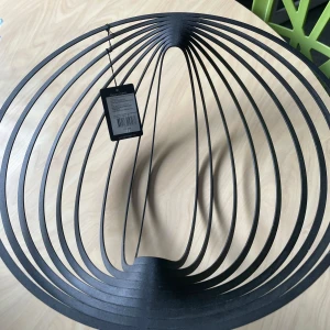 Helt ny fruktskål - Bilderna visar en modern, svart metallskål med ett unikt, öppet designmönster. Det är ingen bok på bilderna, utan snarare en dekorativ inredningsdetalj, troligen avsedd för frukt eller som prydnad. Ingen information om boktitel, författare eller innehåll kan identifieras.