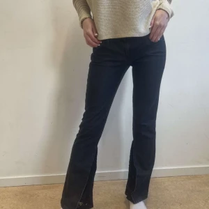 Svarta jeans med spets - Snygga svarta jeans med låg midja och bootcut-stil. Byxorna har en cool slits av spets som ger en unik touch. Perfekta för en trendig look. Storlek S, midjemått 39cm, innerbenslängd 73cm💕