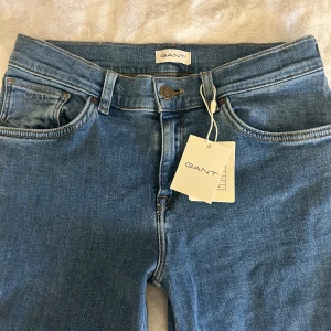 Blå jeansbyxor från GANT - Snygga blå jeansbyxor från GANT med bootcut-stil. De har en klassisk femficksdesign och en bekväm passform. Perfekta för en avslappnad look.