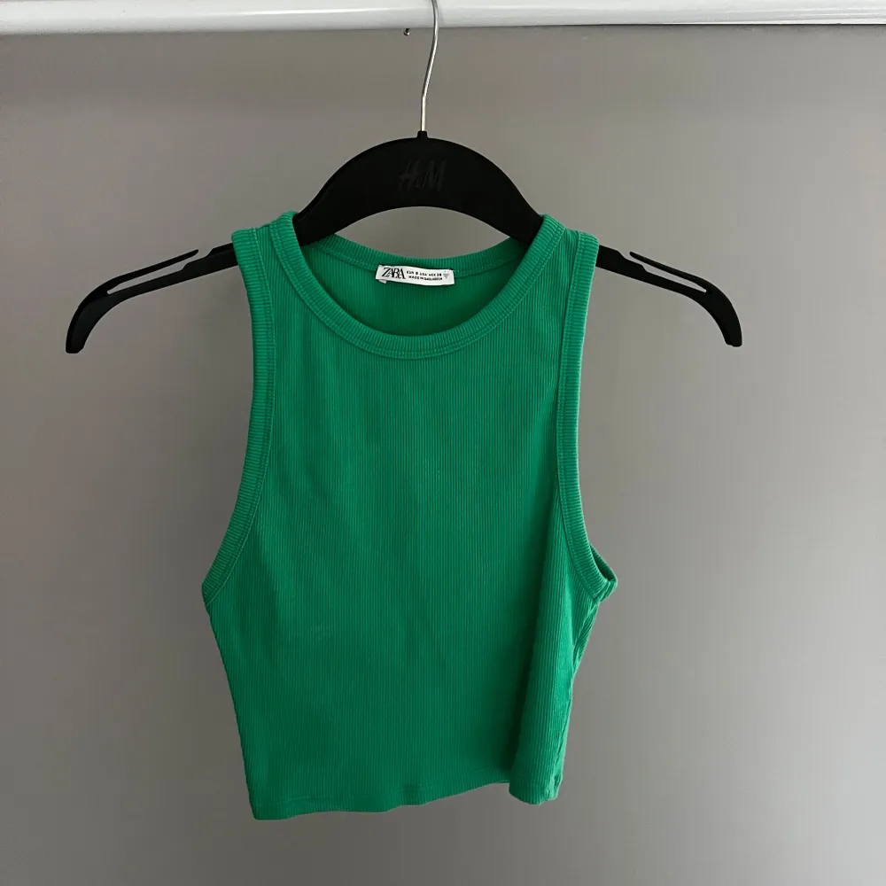 Säljer en snygg grön ribbad linnetopp från Zara. Toppen är ärmlös och croppad, perfekt för varma dagar. Den har en enkel och stilren design som gör den lätt att matcha med olika outfits.. Yläosat.