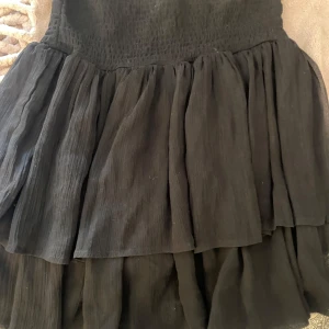 Svart kjol - Svart volang kjol. Lappen är avklippt så vet tyvärr ej märket. Använd men helt som ny