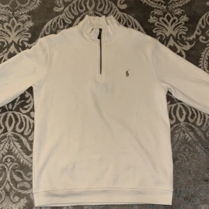 Vit tröja från Ralph Lauren - Säljer en stilren vit tröja från Ralph Lauren med dragkedja vid halsen och det klassiska logotypbroderiet på bröstet. Perfekt för en avslappnad men ändå snygg look. Pris kan diskuteras 