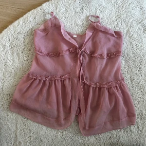 Rosa topp med volangdetaljer - Säljer en jättefin rosa topp perfekt till sommarn!💕jag har sytt upp banden på toppen själv💕 nästan aldrig använd 