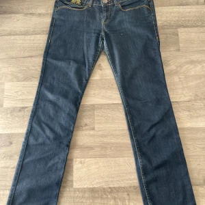 Blå jeans från Killah - Säljer ett par blå vintage jeans från Killah  i mycket bra skick.  Oklart vilken storlek det är men jag är 163 och de passar perfekt på mig i längden, och midjemått kan ni se på bilden. Nypris ca 1900kr, säljer för 500kr. Pris går eventuellt att diskutera