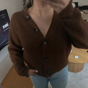 Brun stickad kofta från Gina Tricot - I bra skick, lite nopprig. Mysig brun stickad kofta från Gina Tricot med stora knappar framtill. 