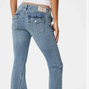 Blå jeansbyxor från True Religion - Snygga blå jeansbyxor från True Religion med bootcut-stil. Byxorna har en klassisk femficksdesign och dekorativa sömmar på bakfickorna. Perfekta för en avslappnad look. Dessa år lågmidjade och passar mig bra i längd och jag är 163❤️ dessa är som nya.