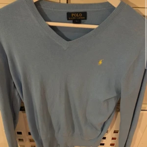 Tröja polo Ralph lauren - Säljer en stilren ljusblå tröja från Polo Ralph Lauren med v-ringning och långärmad design. Den är 10/10 i skick. Nypris 1499.