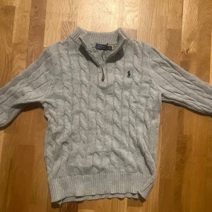 Grå stickad tröja från Polo Ralph Lauren - Säljer en stilren grå stickad halv zip tröja från Polo Ralph Lauren. Storleken är S men passar även M. Den är perfekt för kyliga dagar! Priser går såklart att diskutera