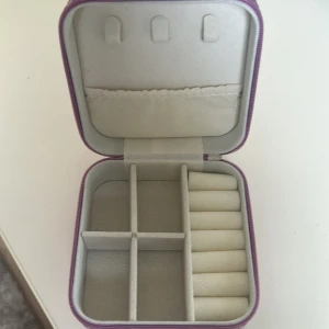 Rosa smyckeskrin med dragkedja - Snyggt och praktiskt smyckeskrin med dragkedja. Perfekt för att organisera dina smycken med flera fack och en sektion för ringar.  Säljer på grund av att den inte kommer till användning för mig, så aldrig använd🩷