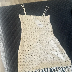 Beige klänning/ cover up  från Zara - Säljer en snygg beige klänning från Zara. Klänningen har smala axelband. Perfekt för sommardagar och strandhäng helt ny aldrig använt 