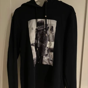 Svart hoodie från Limitato - Snygg svart hoodie från Limitato med ett coolt tryck på framsidan. Perfekt för en avslappnad stil med en touch av attityd. Den har långa ärmar och en klassisk huva med dragsko.