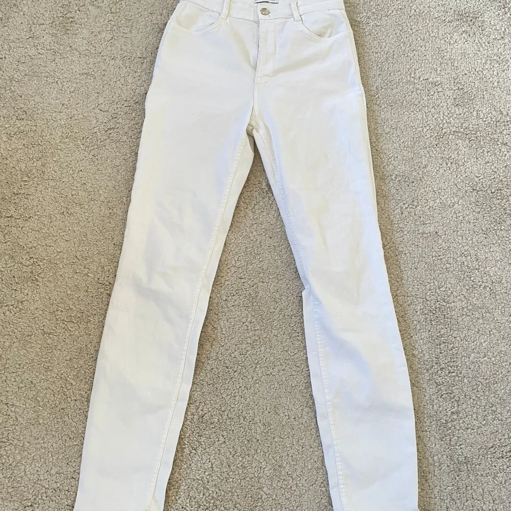 Snygga vita byxor från Zara i en klassisk stil. De har en rak passform och är tillverkade i ett bekvämt material. Perfekta för en stilren look.. Farkut & Housut.