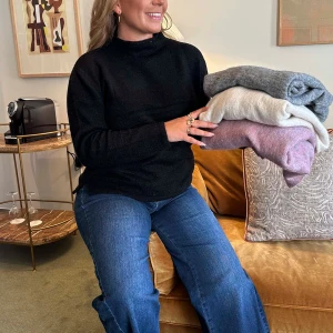 Svart stickad polotröja - Säljer en stilren svart stickad polotröja med hög krage. Perfekt för kyligare dagar och enkel att matcha med olika outfits. Tröjan har långa ärmar och en klassisk design. Köptes för 899kr