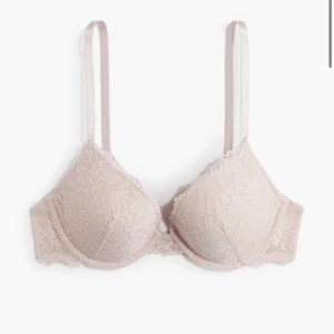 Beige spets-bh - Elegant beige bh med spetsdetaljer och justerbara axelband. Perfekt för en stilren och bekväm look.