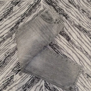 Grå jeans från Bershka - Snygga grå jeans från Bershka med en klassisk design. De har en rak passform och är tillverkade i ett slitstarkt denimtyg. Perfekta för en avslappnad stil.