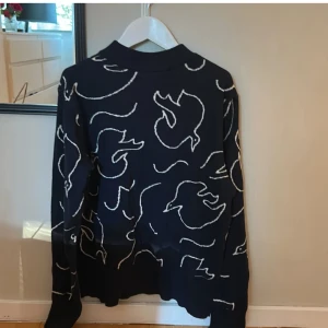 Marinblå tröja med abstrakt mönster - Säljer en mörkblå tröja med ett unikt vitt mönster. Tröjan har långa ärmar och en bekväm passform. Perfekt för att ge din garderob en stilfull touch. Tunnt material, säljer pga att jag inte använder den. Strl xxs men passar xs💓