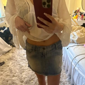 Jeanskjol i blå denim - Snygg och trendig kort jeanskjol i blå denim. Perfekt för en avslappnad stil. Kjolen har en klassisk femficksdesign och en lätt slitning för en cool look. Säljer då den inte kommer till använing💕💕