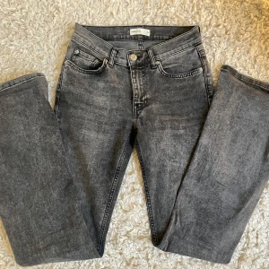 Grå jeans med utsvängda ben - Säljer ett par snygga grå jeans med utsvängda ben. Perfekta för en avslappnad stil och passar till många olika toppar. De har en klassisk femficksdesign och knappgylf. Nyskick (nypris: 599)