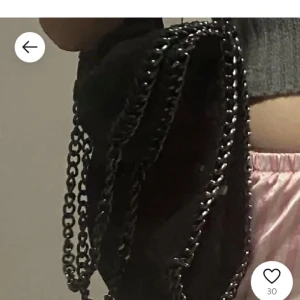 Stella McCartney väska  - Inte äkta. Snygg svart axelväska med coola kedjedetaljer. Perfekt för att ge din outfit en edgy touch. Väskan har en stilren design och passar till många olika stilar.