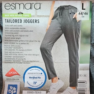 Grå business-joggers från Esmara - Snygga och bekväma grå business-joggers från Esmara. Tillverkade i en mjuk blandning av viskos och polyester med elastan för stretch. De har en elastisk dragsko i midjan och sidofickor. Byxorna har en avsmalnande passform och modern ankelängd.